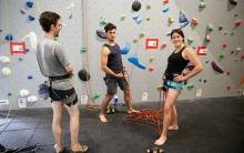 2 men and 1 woman climbers preparing ropes to climb